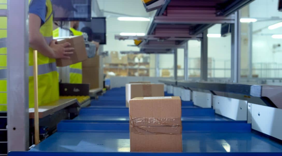 workers sorting packages conveyor system