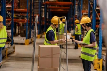 warehouse employees scanning retail inventory for shipping.